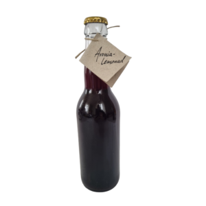 Flaska med aronialemonad med mörk färg och enkel etikett.