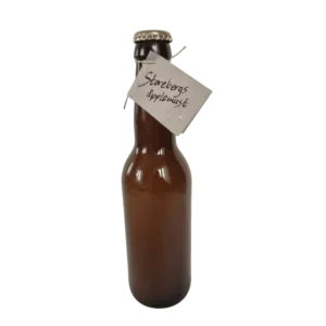 Flaska med Storebergs äpplemust från Fristorps gård med naturlig färg och etikett.